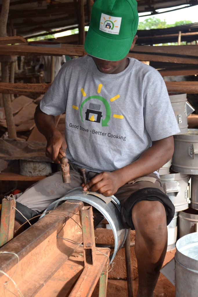 A Ugandan man is working on an improved cookstove made of stainless steel.