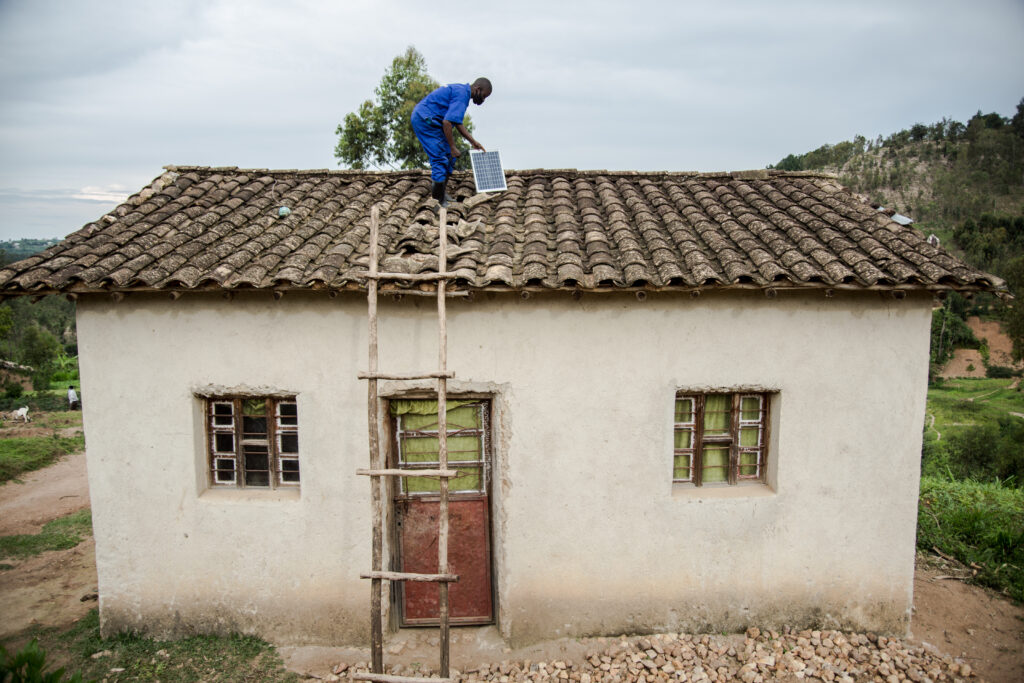 A technician installing a solar home system.